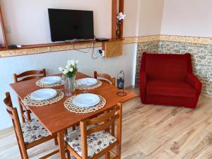 uma sala de jantar com uma mesa e uma cadeira vermelha em Mikszáth Apartman em Balatonfüred