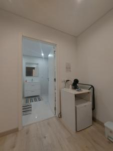 une pièce blanche avec un lavabo et un miroir dans l'établissement Nazaré Holidays, à Nazaré 40 autres photos