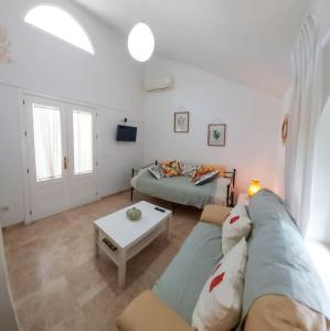 ein Wohnzimmer mit einem Sofa und einem Tisch in der Unterkunft Ático Joaquín Costa 15 Alameda de Hércules in Sevilla