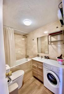 a bathroom with a toilet and a washing machine at LuxBenidorm in Benidorm