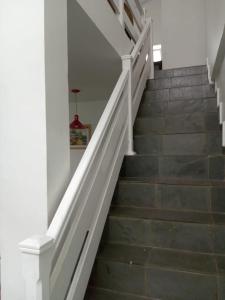 a staircase with white railings and wood floors at Paraíso de Verão - Disfrute final de semana em Casa Exclusiva com piscina, sinuca e churrasqueira Aluguel para temporada em Riviera de São Lourenço in Bertioga