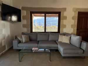 een woonkamer met een bank en een glazen tafel bij Villa Recluso-3 bd luxury country villa, huge pool with hydromassage, individual bbq & large yard, mountain view in Maláxa