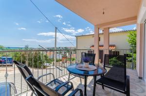 Un patio con una mesa y sillas en un balcón. en Apartmani Lorena, en Okrug Gornji