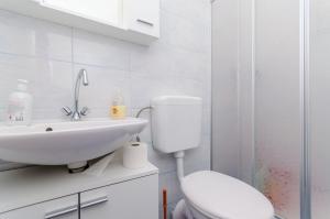 Un baño blanco con inodoro y lavabo. en Apartmani Lorena, en Okrug Gornji 19 fotos más