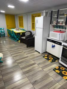 una cucina con un frigorifero bianco e un tavolo di Casa com piscina e salão de jogos para aluguel de temporada e finais de semana em Torres/RS. a Torres