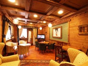 ein Wohnzimmer mit Stühlen, Tischen und einem Fernseher in der Unterkunft Hotel Tersiva in Valtournenche