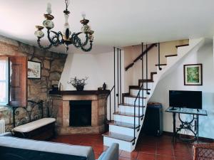 ein Wohnzimmer mit einer Treppe und einem Kamin in der Unterkunft Casa Cabreiros de Cima in Melgaço