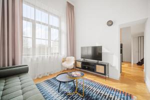a living room with a couch and a tv at Owl Jazz Apartments - luxury apartments in the heart of the city in Kaunas