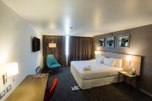 Habitación de hotel con cama y escritorio en BTH Rebel Tacna en Tacna