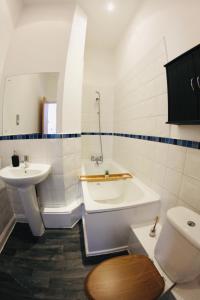 ein Badezimmer mit einer Badewanne, einem WC und einem Waschbecken in der Unterkunft Lovely Studio Apartment in the Heart of Nottingham in Nottingham