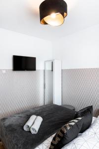 a bedroom with a bed with two towels on it at ClickTheFlat Conrada Apart Rooms in Warsaw