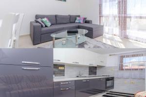 a living room with a gray couch and a kitchen at Apartmani Selo Luka in Ražanj