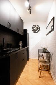 華沙的住宿－ClickTheFlat Conrada Apart Rooms，厨房配有桌子和墙上的时钟