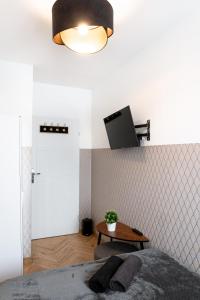 1 dormitorio con 1 cama y 1 mesa con TV en la pared en ClickTheFlat Conrada Apart Rooms, en Varsovia