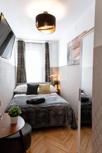 niewielka sypialnia z łóżkiem i stołem w obiekcie ClickTheFlat Conrada Apart Rooms w Warszawie