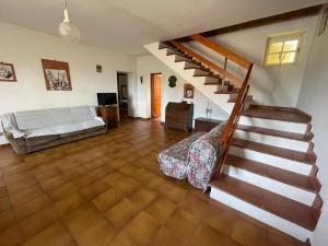a living room with a staircase and a couch at il casale di Bruno e Pina in Pantana