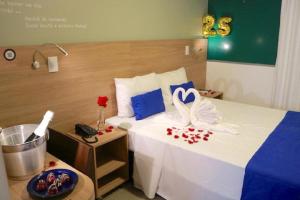 um quarto de hotel com uma cama com dois cisnes em Hotel Del Fiol em Tatuí