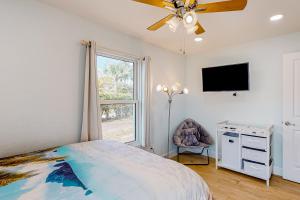 a bedroom with a bed and a dresser and a tv at Casa Capel in Port Orange