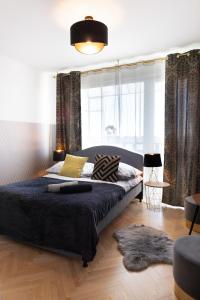 sypialnia z dużym łóżkiem z niebieską kołdrą w obiekcie ClickTheFlat Conrada Apart Rooms w Warszawie
