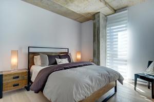1 dormitorio con cama grande y ventana grande en Les Immeubles Charlevoix - Le 760608, en Quebec