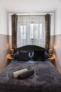 ein Schlafzimmer mit einem großen Bett mit zwei Kissen darauf in der Unterkunft ClickTheFlat Conrada Apart Rooms in Warschau