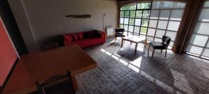 sala de estar con sofá rojo y mesa en GreJa Lodge, Limay, Patagonia en Dina Huapi