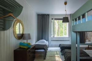 a bedroom with two beds and a mirror and a window at Saarjärve Puhkemaja 32-le, 8 magamistuba in Tromsi