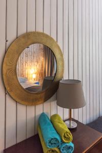 een spiegel aan een muur met een tafel en een lamp bij Saarjärve Puhkemaja 32-le, 8 magamistuba in Tromsi