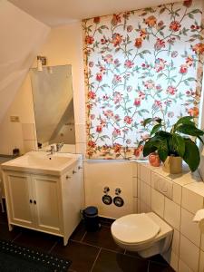 a bathroom with a toilet and a flower shower curtain at Ferienwohnung Geißler in Bad Schandau