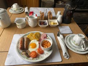 a table with a breakfast plate of eggs sausage and beans at Rhydydefaid Bed and Breakfast, Guesthouse in Frongoch, Snowdonia in Frongoch