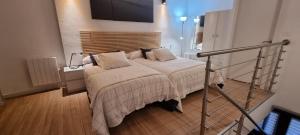 a bedroom with a bed and a tv on the wall at Apartamentos Les Texuques II in Nueva de Llanes