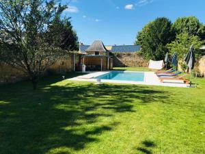 una piscina en un patio con césped en Chambres Calix en La Flèche