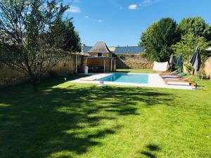 a swimming pool in a yard with a grass field at Chambres Calix in La Flèche
