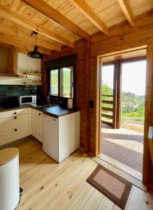 a kitchen in a wooden cabin with a large window at Mountain Eco Shelter 5 in Funchal