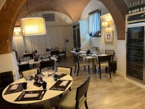 een restaurant met tafels en stoelen en een kamer met wijnflessen bij Molo73 in Empoli
