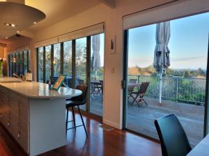 a kitchen with sliding glass doors leading to a deck at Sunshine Valley in Auckland