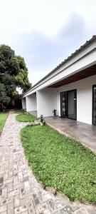 a building with a brick walkway next to a yard at Savanna Tree Apartments - self catering town center in Livingstone