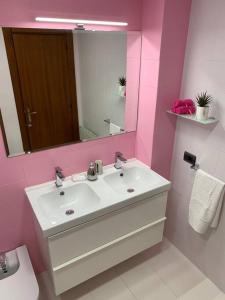 Baño rosa con lavabo y espejo en Alojamiento Rural Harria, en Yécora