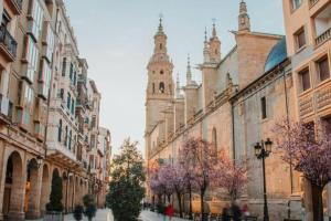 eine Stadtstraße mit Gebäuden und einem Uhrenturm in der Unterkunft Alojamiento Rural Harria in Yécora