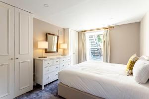 a white bedroom with a bed and a window at Idyllic Islington Flat in London