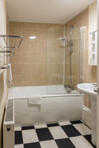 a bathroom with a shower and a tub and a sink at Ilkley Place in Ilkley