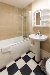 a bathroom with a sink and a toilet and a tub at Ilkley Place in Ilkley