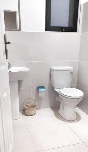 a white bathroom with a toilet and a sink at Savanna Tree Apartments - self catering town center in Livingstone