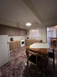 a large kitchen with a table and a refrigerator at Family House Anavissos in Anavissos