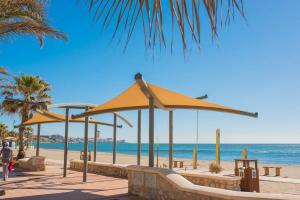 フエンヒロラにあるFuengirola, Primera linea de playaの黄色い傘と海のビーチ