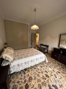 a bedroom with a bed and a chandelier at Family House Anavissos in Anavyssos