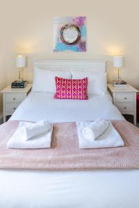 a bedroom with a white bed with two towels on it at Ilkley Place in Ilkley