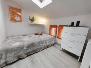 ein Schlafzimmer mit einem Bett, einer Kommode und einem Fenster in der Unterkunft Apartament Mały Monciak in Sopot