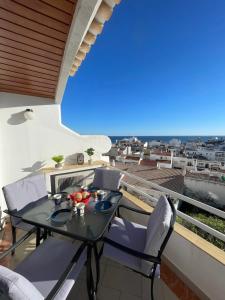 patio ze stołem i krzesłami na balkonie w obiekcie Apartamento Varandas do Mar w Albufeirze