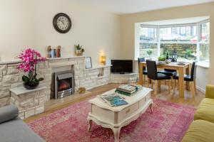 a living room with a fireplace and a table at Ilkley Place in Ilkley